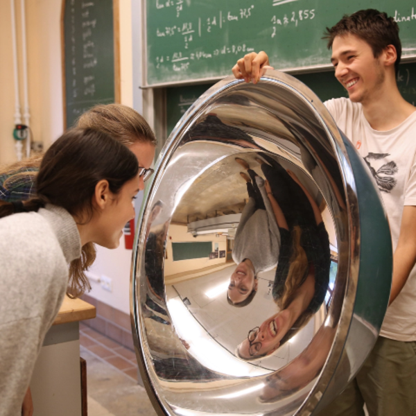 Kinder spiegeln sich in einer großen Metallschale
